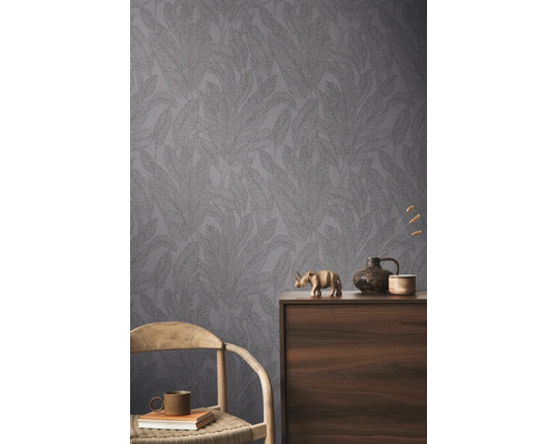 Zimmeransicht mit gemusterter Tapete und dekorativen Elementen auf einem Holzschrank.