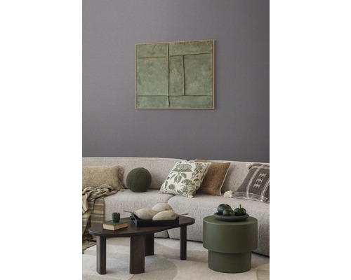 Wohnzimmer mit Couch, Kissen, Tisch und Wandbild