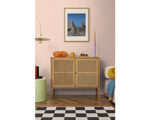 Wohnzimmer mit Kommode aus Rattan, Kunstwerk und dekorativen Accessoires für ein stilvolles Interieur