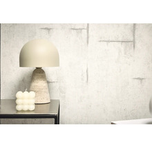 Dekorative Tischleuchte mit Travertinfuß neben Bubble-Kerze auf einem Tisch