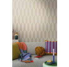 Helles Wohnzimmer mit gemusterter Tapete, grauem Sofa und dekorativen Elementen wie Kissen und Decken