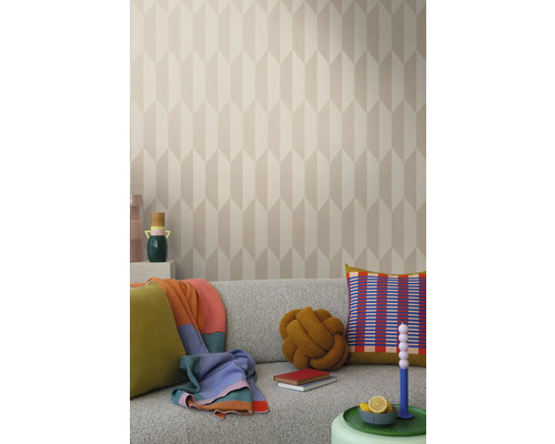 Helles Wohnzimmer mit gemusterter Tapete, grauem Sofa und dekorativen Elementen wie Kissen und Decken