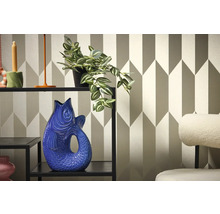 Dekorative Inneneinrichtung mit Regal, Pflanze und Fischvase vor geometrischer Tapete.