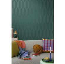 Wohnzimmer mit grauer Couch, Kissen, Decken und gemusterter Tapete für eine stilvolle Inneneinrichtung.