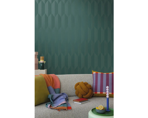 Wohnzimmer mit grauer Couch, Kissen, Decken und gemusterter Tapete für eine stilvolle Inneneinrichtung.