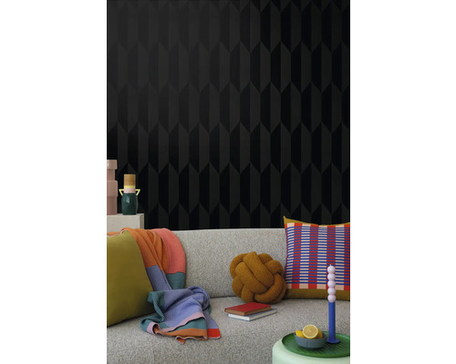 Wohnzimmer mit schwarzer Tapete mit geometrischem Muster und Couch