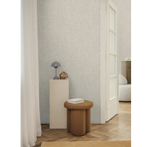 Heller Raum mit gemusterter Tapete, Hocker und Dekorationen für ein stilvolles Interieur.