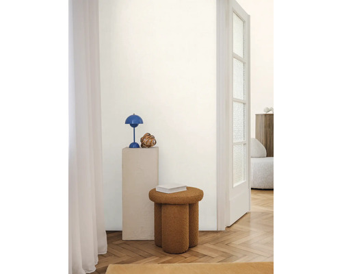 Innenraum mit dekorativem Hocker, Tischlampe und Beistelltisch