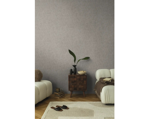 Wohnzimmer mit gemusterter Tapete, Teppich, Sofa und Beistelltisch.