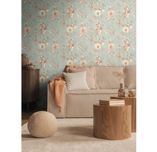 Wohnzimmer mit blumiger Tapete, geripptem Sofa und Holztischen