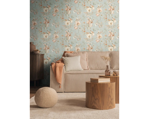 Wohnzimmer mit blumiger Tapete, geripptem Sofa und Holztischen