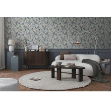 Wohnzimmer mit gemusterter Tapete, Sofa, Teppich und Holzelementen für eine gemütliche Atmosphäre