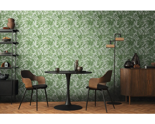 Wohnzimmer mit Esstisch, Stühlen, Regal, Schrank und einer Tapete mit Pflanzenmuster.