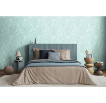 Schlafzimmer mit Bett, Nachttischen und Tapete mit Blattmuster für ein entspannendes Ambiente.