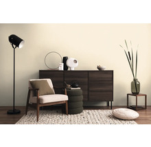 Wohnzimmer-Szene mit Kommode, Sessel, Stehlampe und dekorativen Elementen auf einem Teppich