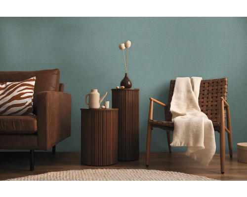 Wohnzimmer mit Sofa, Stühlen und Beistelltischen vor einer Wand