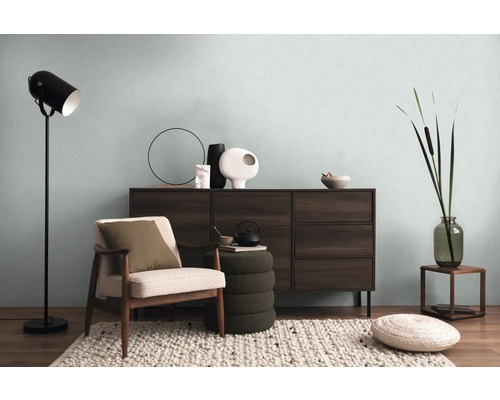 Wohnzimmer mit Kommode, Sessel, Stehlampe und dekorativen Elementen für eine gemütliche Atmosphäre