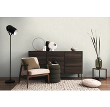 Wohnzimmer mit Sessel, Kommode, Stehlampe und Dekorationen für eine gemütliche Atmosphäre.