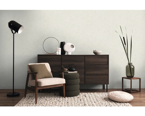 Wohnzimmer mit Sessel, Kommode, Stehlampe und Dekorationen für eine gemütliche Atmosphäre.