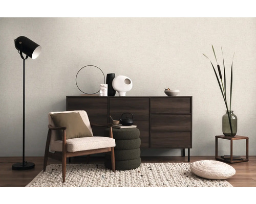 Innenraum mit Sessel, Stehlampe, Kommode und dekorativen Elementen für ein gemütliches Wohnambiente.