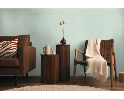 Wohnzimmer mit Sofa, Stuhl und Beistelltischen in hellem Ambiente