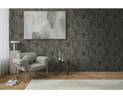 Wohnzimmer mit Sessel, Tisch und Dekoration vor einer strukturierten Wand