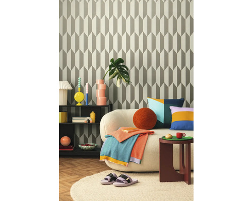 Wohnzimmer mit gemusterter Tapete, Sofa, Beistelltisch und Dekorationen für ein gemütliches Ambiente.