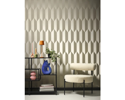 Raumansicht mit gemusterter Tapete, Regal und Sessel