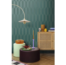 Innenraum mit dekorativer Wand, Lampe, Kommode und Dekorationselementen für ein stilvolles Ambiente.