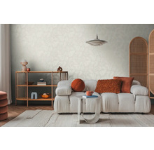 Helles Wohnzimmer mit gemusterter Tapete, Sofa, Teppich und Holzregal