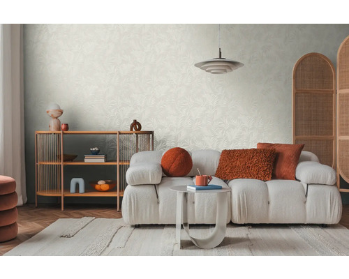 Helles Wohnzimmer mit gemusterter Tapete, Sofa, Teppich und Holzregal