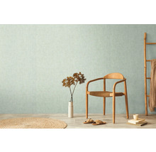 Wohnraum mit gemusterter Tapete, Holzstuhl und Deko-Elementen für ein helles Ambiente