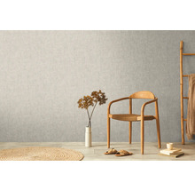 Szene mit Vliestapete an der Wand, Stuhl, Dekoration und Teppich.