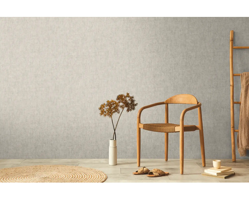 Szene mit Vliestapete an der Wand, Stuhl, Dekoration und Teppich.