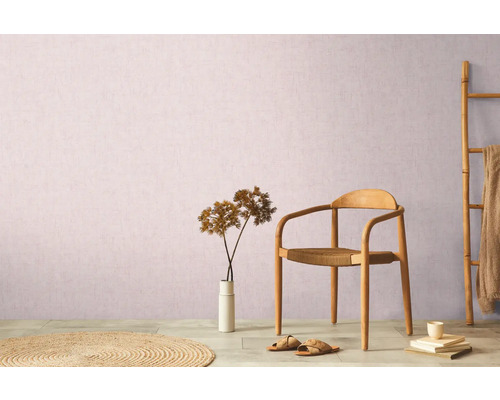 Dekorative Wohnrauminszenierung mit Stuhl, Teppich, Dekoration und Bambusleiter vor einer Wand.