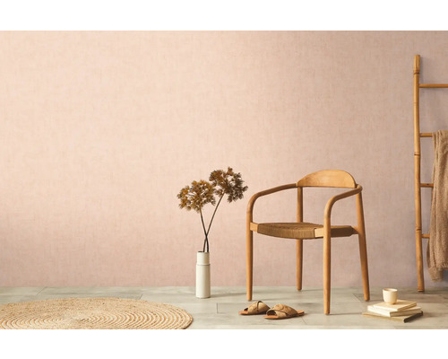 Dekoratives Wohnambiente mit Holzstuhl, Teppich und Zimmerpflanze vor einer dezenten Wand