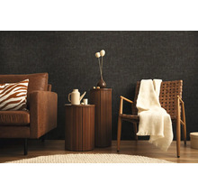 Wohnzimmer mit Sofa, Sessel und Beistelltischen vor einer dunklen Wand