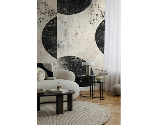 Wohnzimmer mit einer Couch, einem Teppich, Beistelltischen und einer gemusterten Tapete