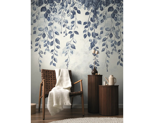 Dekorative Tapete mit Blattmuster in einem stilvollen Wohnzimmer mit Sessel und Beistelltischen.