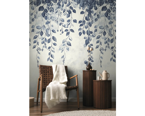 Dekorative Wand mit Blattmuster, Sessel mit Decke und Beistelltische im Wohnzimmer.