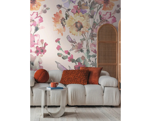 Wohnzimmer mit Sofa, Tisch, Kissen und floraler Tapete für eine gemütliche Atmosphäre