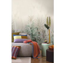 Wohnzimmer mit Sofa, Kissen, Decke und Pflanzenmotiv-Tapete