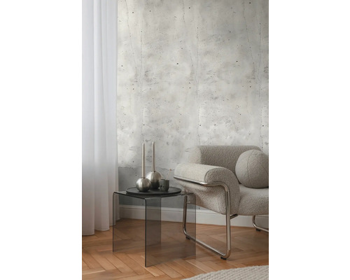 Innenraum mit Betonwandtapete, Sessel und Beistelltisch