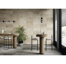 Heller Raum mit Wand- und Bodenfliesen, Tischen, Stühlen und Zimmerpflanze