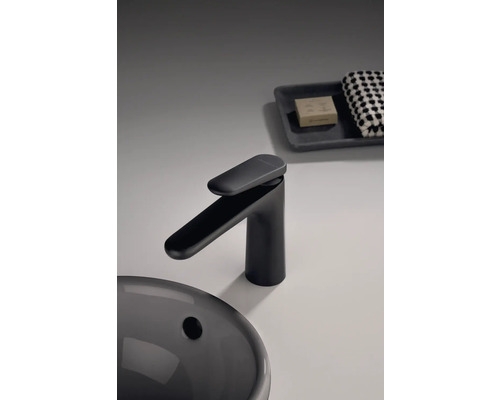 Schwarze Waschtischarmatur neben Waschbecken, Seife und Handtuch