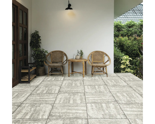 Terrasse mit zwei Rattanstühlen und kleinem Tisch auf Steinboden