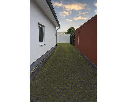 Einfahrt mit Rasengittersteinen zwischen Haus und Garage
