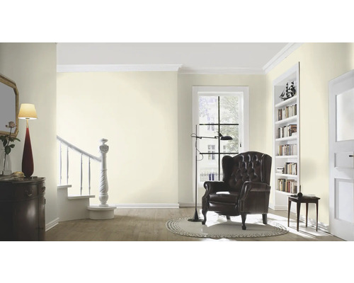 Helles Wohnzimmer mit Sessel, Bücherregal und Treppe