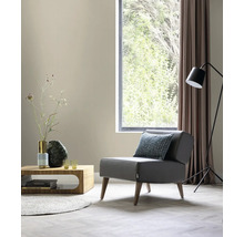 Wohnzimmer mit Sessel, Tisch, Stehlampe und Fenster für eine helle und organisierte Atmosphäre.