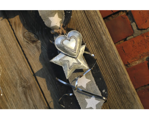 Dekoration mit Herz- und Sternmotiven an einem Band mit Sternmuster